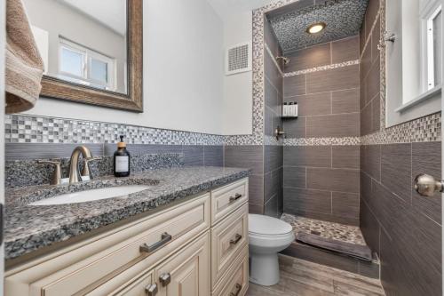 a bathroom with a sink and a toilet and a mirror at Cozy Orem House - Playground - Game Rm - Bunk Rm in Orem