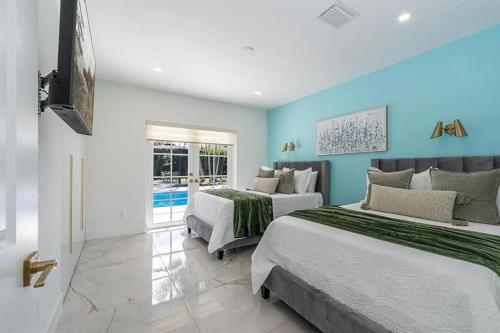 two beds in a room with blue walls at Guest Fav | 5BR Pool Estate | Sleeps 16 in Palmetto Bay