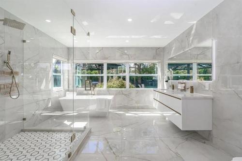 a white bathroom with a tub and a sink at Guest Fav | 5BR Pool Estate | Sleeps 16 in Palmetto Bay
