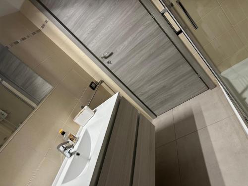 a bathroom with a white sink and a shower at Giusi home in Cologno Monzese