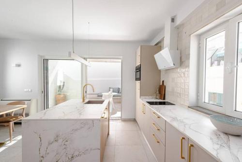 a kitchen with marble counter tops and a large window at Casa Sala - Private Rooftop Swiming Pool in Olhão
