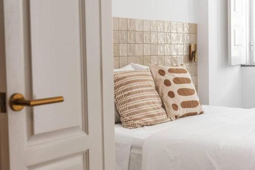 a bedroom with a bed with pillows on it at Casa Sala - Private Rooftop Swiming Pool in Olhão