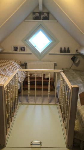 a attic bedroom with two bunk beds and a window at De Knol in Hoek