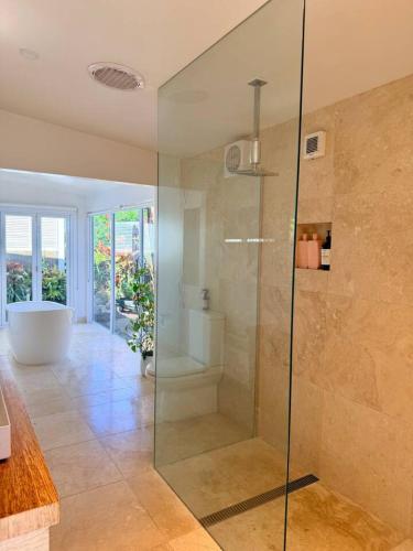 a bathroom with a glass shower and a tub at Shorebreak Port Campbell in Port Campbell