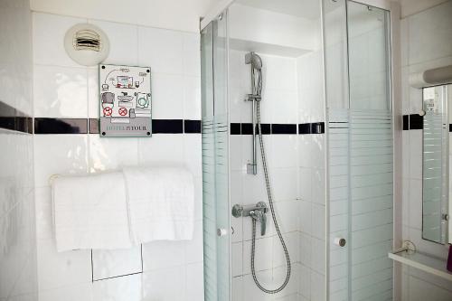 a bathroom with a shower with a glass door at Hotel de la Tour in Paris