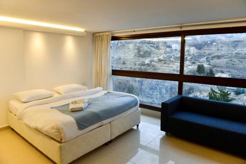 a bedroom with a bed and a large window at Aspen - Duplex 1-BR in Faraya in Fārayyā
