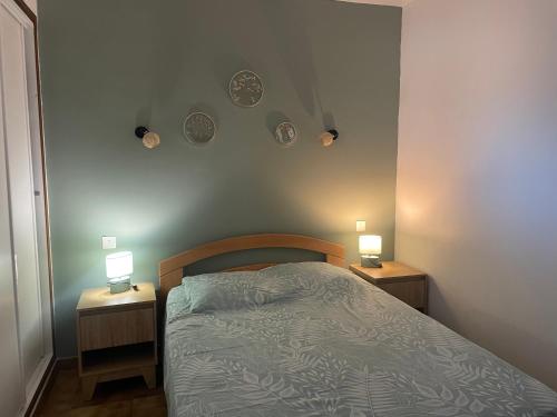 a bedroom with a bed and two lights on the wall at L'Écrin de Sauge- jolie Terrasse in Gréoux-les-Bains