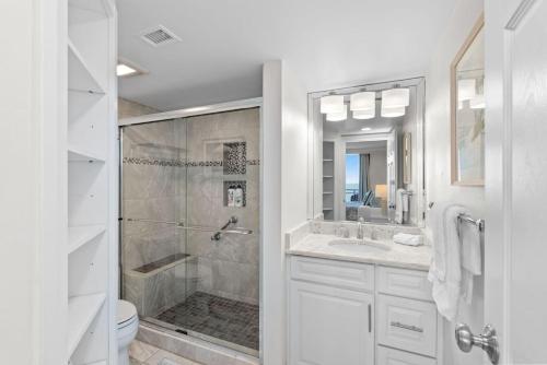 a white bathroom with a shower and a toilet at New Beachfront Condo Pool Surfing Fishing in Virginia Beach
