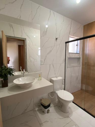 a bathroom with a sink and a toilet and a shower at Casa Portal Carrancas in Carrancas