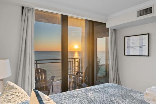 a bedroom with a bed and a view of the ocean at New Beachfront Condo Pool Surfing Fishing in Virginia Beach