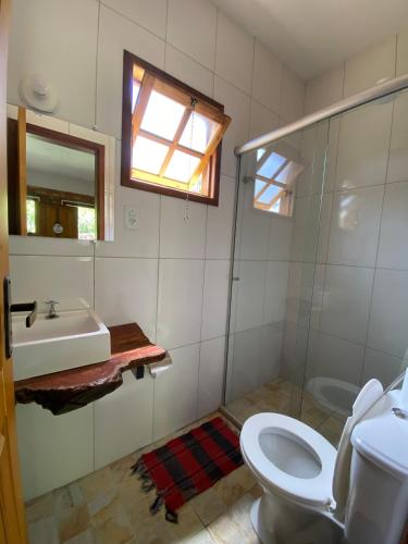 a bathroom with a sink and a toilet and a window at Chalé Ouro in Ouro Preto