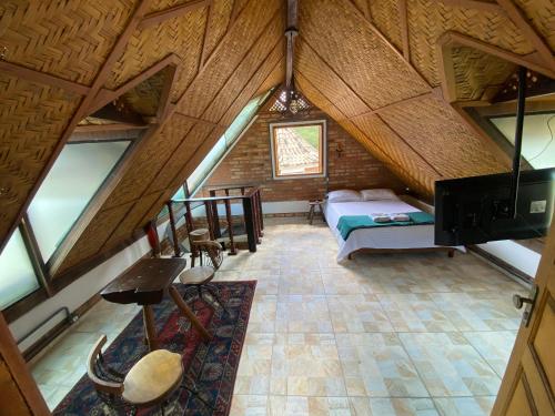 a room with a bed in a attic with windows at Chalé Ouro in Ouro Preto