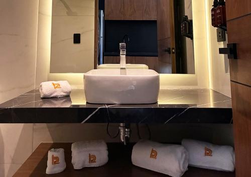 a bathroom with a sink and towels on a counter at Hotel Suites Regente Cholula in Cholula