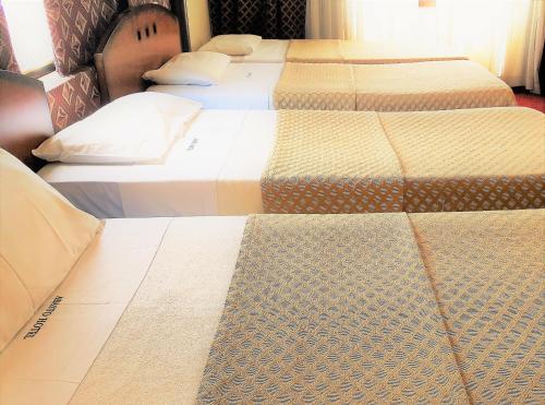 a row of three beds in a room at Abasto Hotel in Buenos Aires