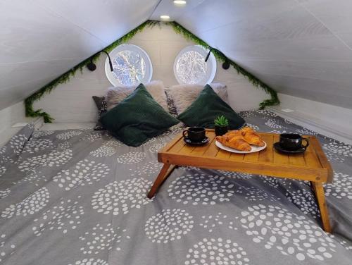a room with a table with food on a bed at Koidula Tiny House in Narva-Jõesuu