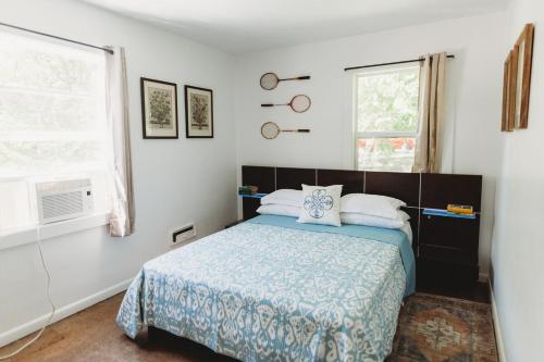 a bedroom with a bed and two windows at Charming Cottage w Hot Tub in Myers Airport
