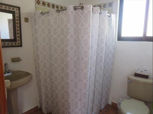 a bathroom with a shower curtain and a toilet at Rincones de Tequis in La Tortuga