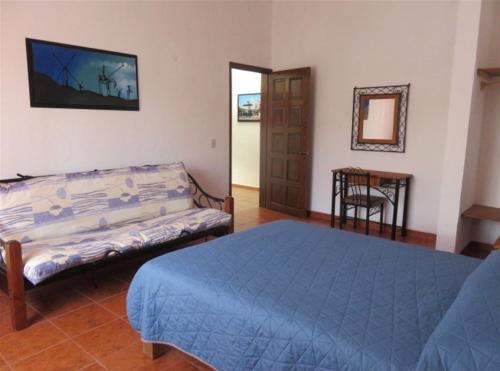 a bedroom with a bed and a table and a mirror at Rincones de Tequis in La Tortuga