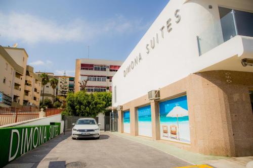 a car parked in front of a building with an umbrella at BLUESEA Dimona Suites in Torremolinos