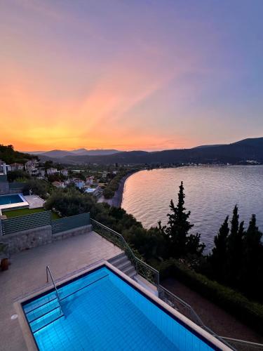 a swimming pool with a view of a body of water at Villa Korina in Nea Epidavros