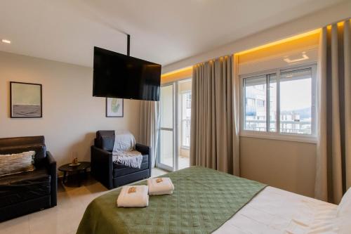 a bedroom with a bed and a chair and a couch at Prime Stay 2102 in Guarulhos