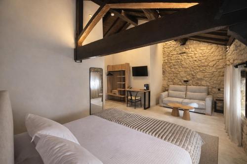 a bedroom with a white bed and a couch at Hotel El Paraíso del Pas in Barcenilla