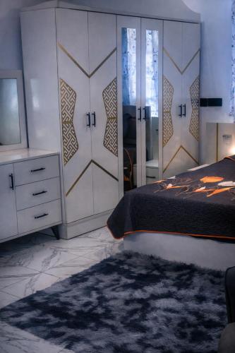 ein Schlafzimmer mit einem Bett, einer Kommode und einem Spiegel in der Unterkunft Perry Hills Apartment in Weija