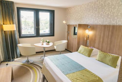 a hotel room with a bed and a table at Mercure Angers Centre de Congrès in Angers