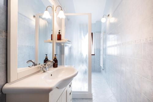a white bathroom with a sink and a mirror at Agriturismo Rebarco in Borsecchio