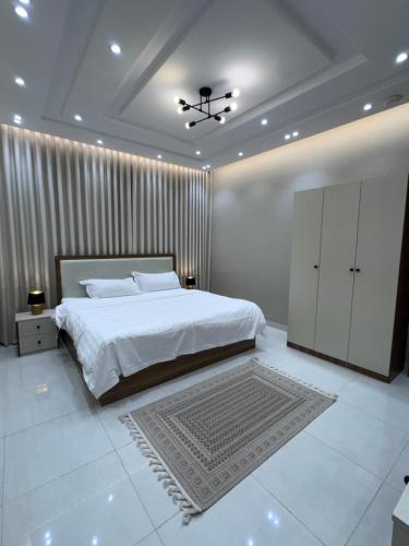 a bedroom with a large white bed and a ceiling at دار مسك الفندقية in Medina