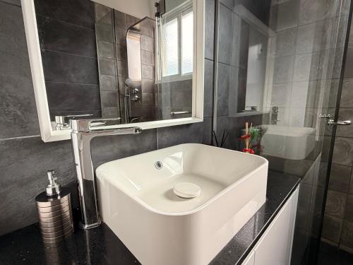 a bathroom with a white sink and a mirror at Zinas modern flat Nicosia in Strovolos