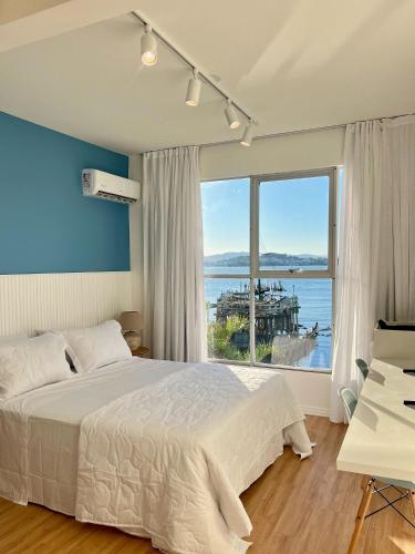 a bedroom with a bed and a large window at Casa Veleiro in Florianópolis