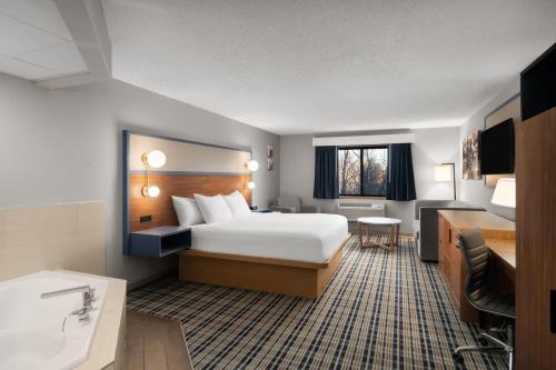 a hotel room with a bed and a desk at AmericInn by Wyndham Tofte Near Lake Superior in Tofte