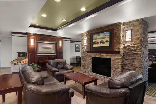a living room with leather furniture and a fireplace at Baymont Inn & Suites by Wyndham Sturgis in Sturgis