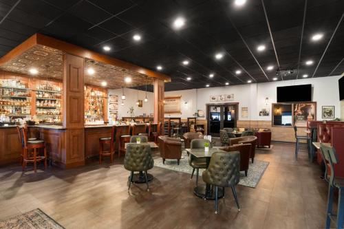 a restaurant with tables and chairs and a bar at Baymont Inn & Suites by Wyndham Sturgis in Sturgis