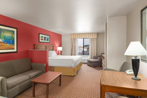 a hotel room with a bed and a couch at Baymont Inn & Suites by Wyndham Sturgis in Sturgis