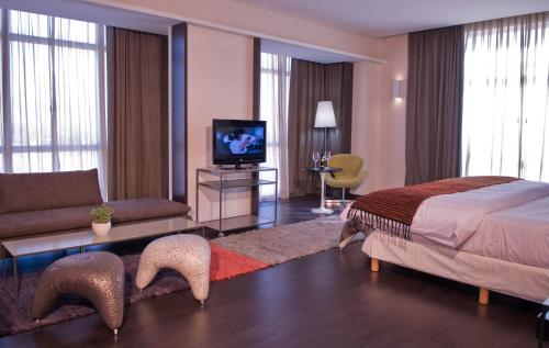 a bedroom with a bed and a living room at Esplendor by Wyndham Mendoza in Mendoza