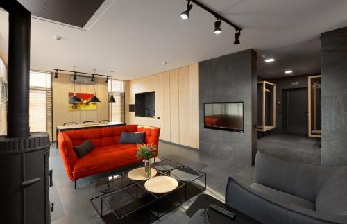 a living room with a red couch and a table at GOOD ZONE Hotel in Peschanka