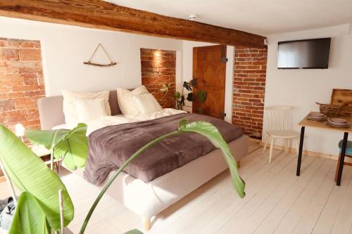a bedroom with a bed and a table with a chair at Klinkerstube in Heuchelheim-Klingen