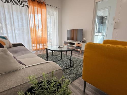 a living room with a couch and a table and a tv at Zinas modern flat Nicosia in Strovolos