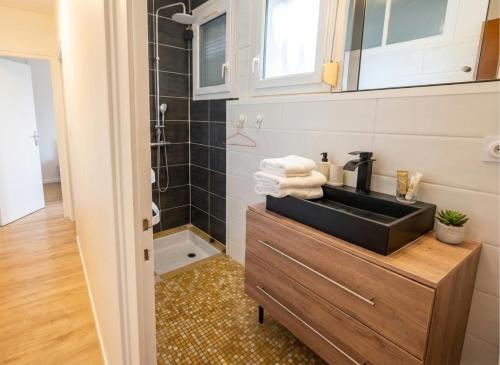 a bathroom with a sink and a shower at Maison plain pied hyper centre avec véranda 5 min à pied plage Royan 3 chambres in Royan