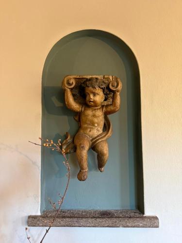 a statue of a monkey sitting on a wall at Casa d'epoca con giardino 5 min da Locarno in Minusio