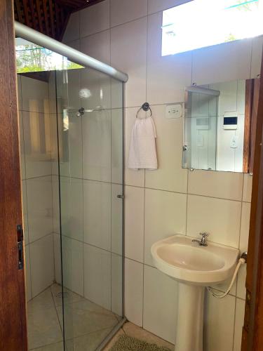 a bathroom with a sink and a glass shower at Chalé Ametista in Ouro Preto