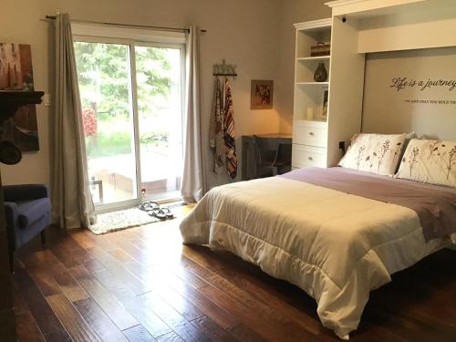 a bedroom with a bed and a large window at Quiet Cozy Luxury on the Thames in Ontario! in London