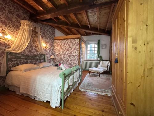 a bedroom with a bed and a chair in a room at Chambre dans un Moulin in Rouy