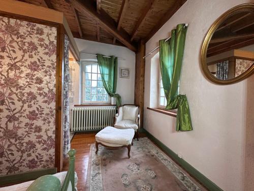 a living room with a chair and a window at Chambre dans un Moulin in Rouy