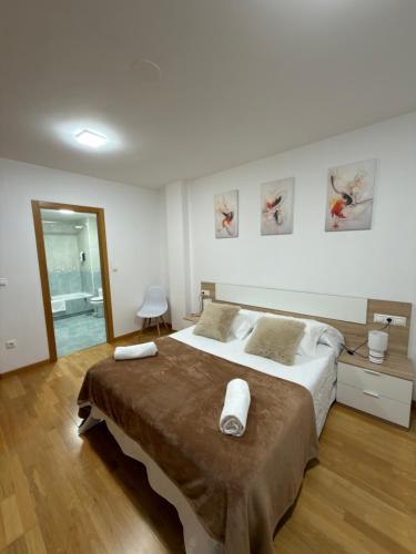a bedroom with a large bed with two towels on it at Villa Arán in Negreira