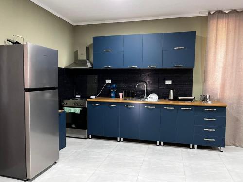 a kitchen with blue cabinets and a stainless steel refrigerator at Rachnari Guest House in Gari