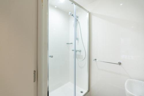 a shower with a glass door in a bathroom at Stylish & Spacious Studio - Prime Briggate Location -Walk Everywhere in Leeds