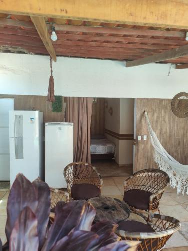 a kitchen with a table and chairs and a refrigerator at Casa Boa Venttura Alugueis - Casa com ar e piscina ou Quartos com ar e cozinha Guajiru Trairi in Trairi